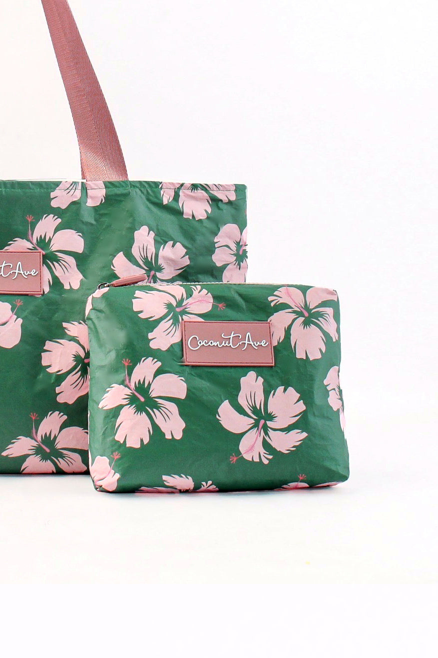 Green bags with pink floral pattern and visible brand label on a white background