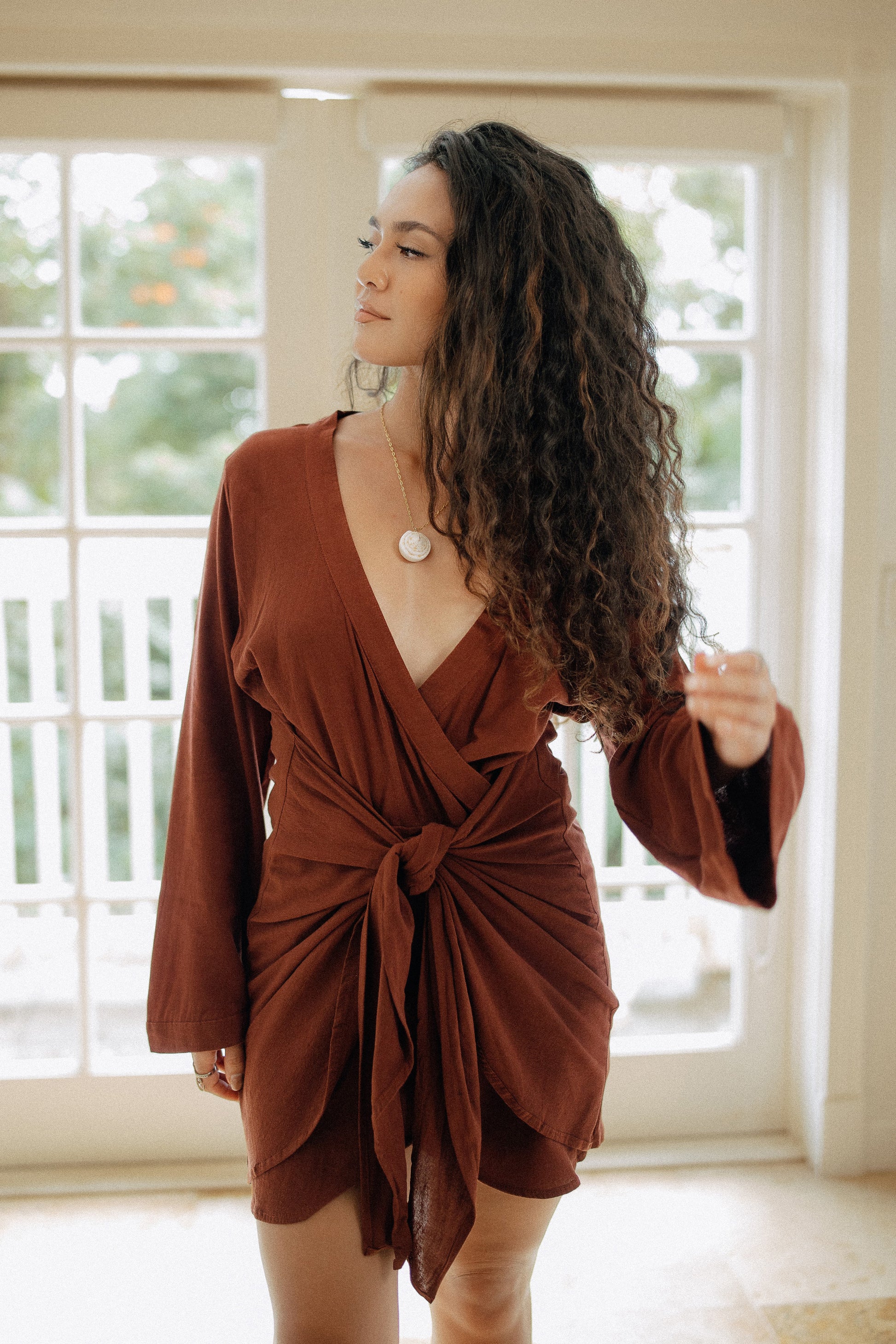 Bora Bora Dress in Chocolate styled with its waist tie detail for an effortless resort day-to-night look.