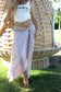 Model wearing Coconut Ave Bamboo Chocolate pareo styled as a lightweight beach cover-up with bamboo stripe tropical print.
