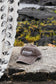 Close-up of the Coconut Ave Dad Hat in Coconut Wireless Vintage Black resting on volcanic rocks, showcasing the embroidered Coconut Wireless logo and vintage washed cotton fabric.