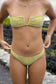 Front view of a woman wearing the Coconut Ave Hippie Bottom in the Moray print with the matching bandeau bikini top, highlighting the high-rise silhouette and green tropical-inspired pattern.