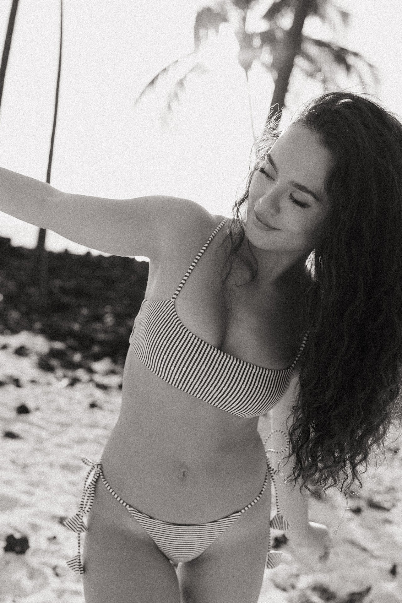 Woman wearing the Pixie Top and matching bikini bottoms in Bamboo Chocolate at the beach
