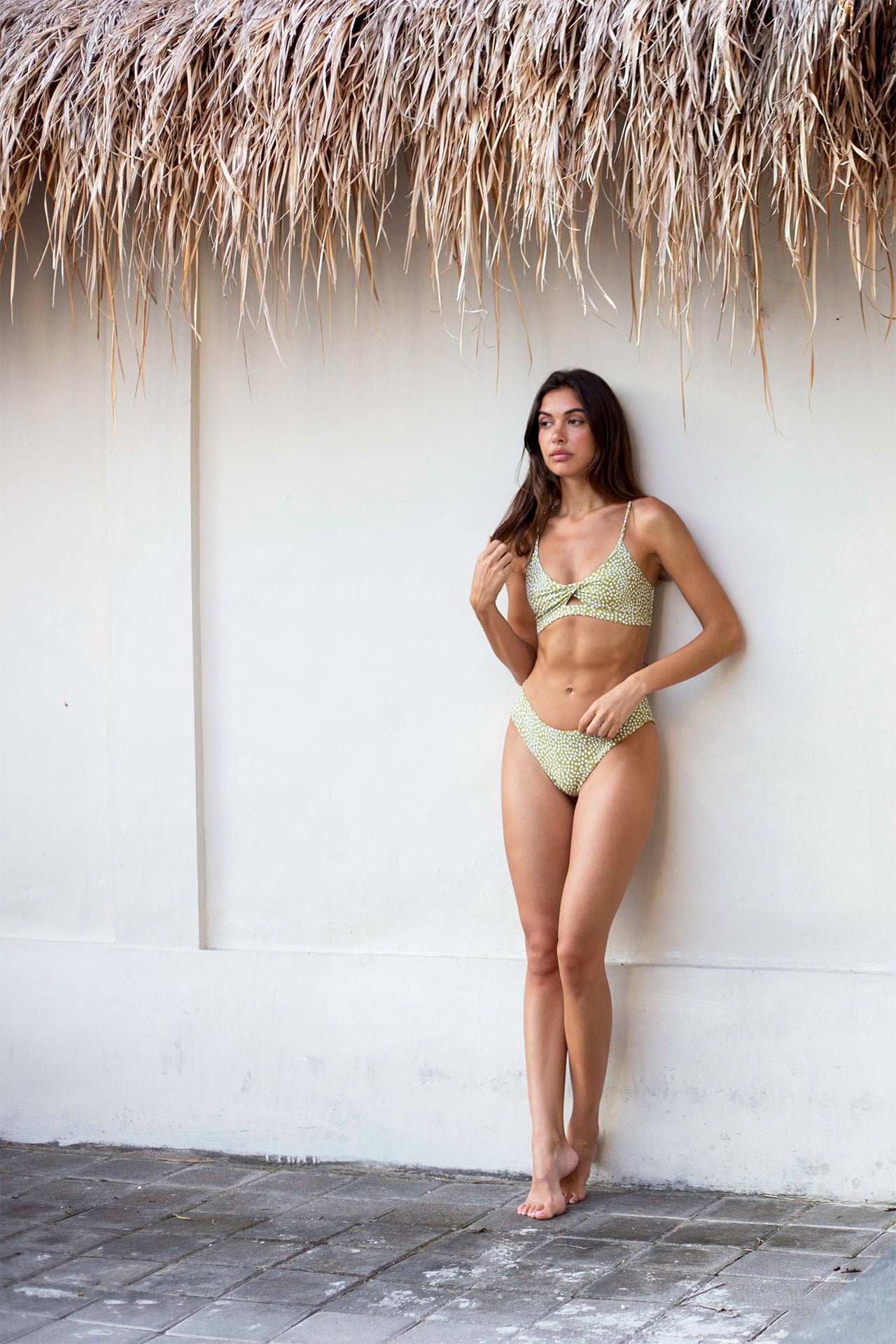 Woman wearing the Hawaiʻi-designed Coconut Ave Twist Bikini Top in the Moray print with matching bikini bottoms, featuring a flattering twist-front design, comfortable stretch fabric, and an island-inspired tropical pattern for beach vacations, poolside lounging, and resort wear.