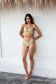 Full-body view of a woman modeling the Coconut Ave Half Scrunch Bottom in the Moray print with matching bikini top, highlighting the flattering medium-rise fit, supportive waistband, recycled stretch fabric, and tropical-inspired green and yellow pattern for beach days, island vacations, and resort wear.