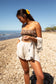 Woman wearing the Coconut Ave Playa Short in Flax at the beach.