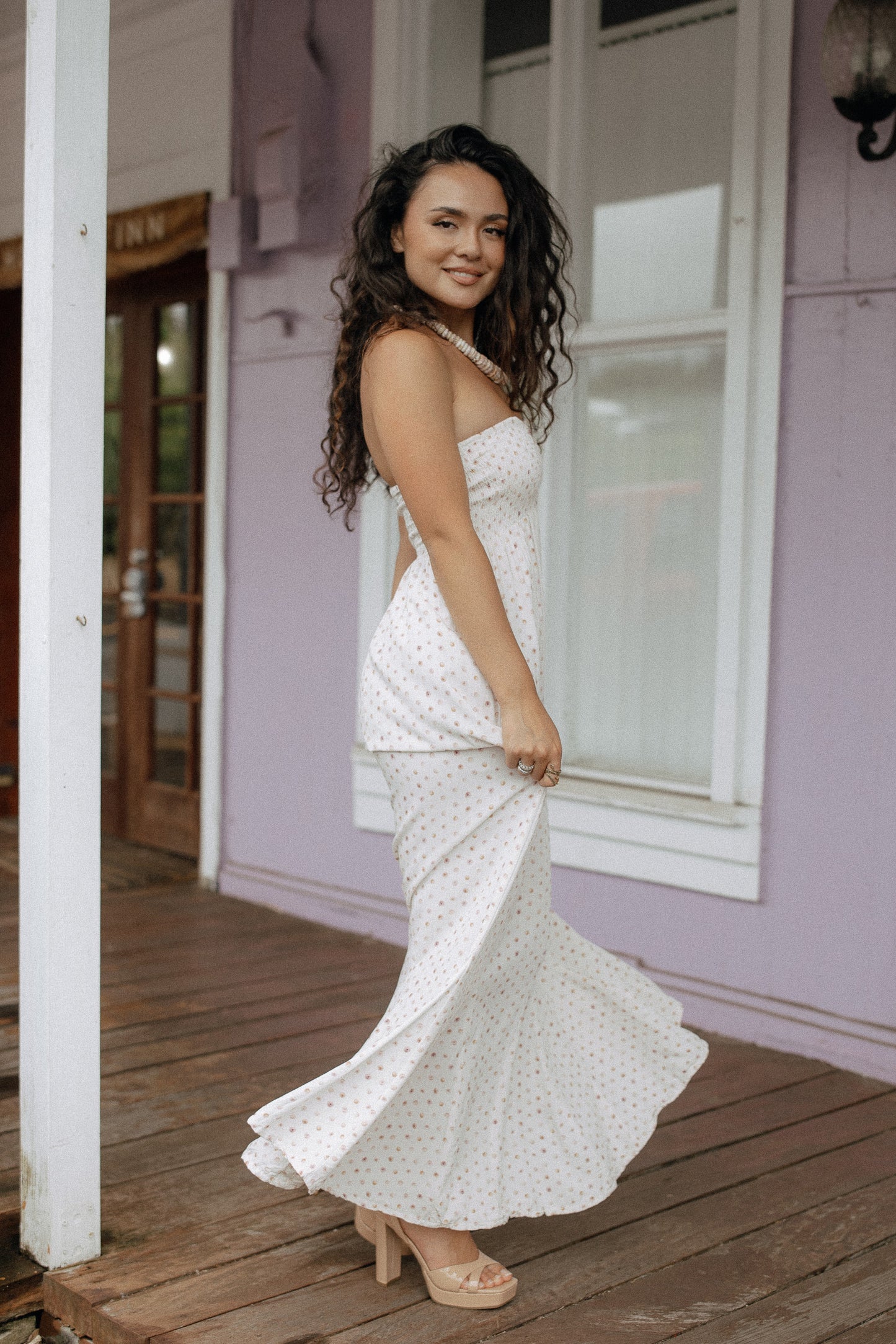 Puka Shell Mau'umae Maxi Dress styled with sandals for relaxed resort wear on a tropical porch.