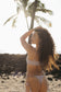 Woman modeling the Bamboo Chocolate Pixie Top while standing on the beach