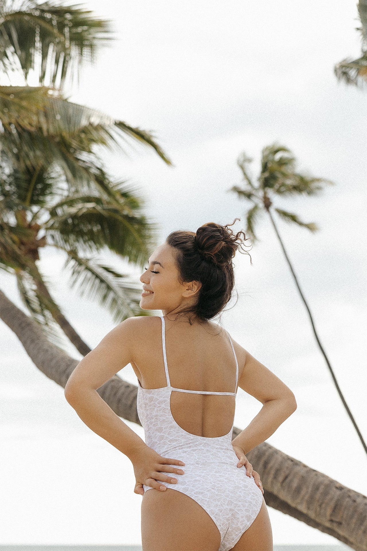 Back and side view of the Stevie One Piece in Hulali print by the beach