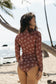 Back view of the Chocolate Bloom Surf Suit with long sleeves on the beach