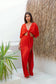 Full-length view of a woman wearing the Coconut Ave Minx Maxi Skirt in Hibiscus paired with a matching crop top. The lightweight linen blend skirt features a flowing maxi silhouette and dramatic high side slit, creating an elegant tropical resort outfit.